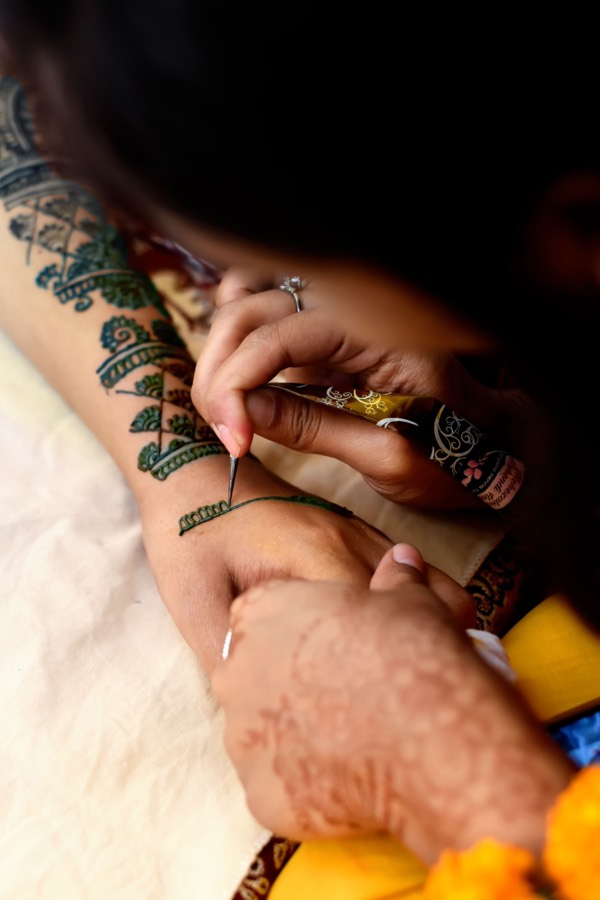 Mehendi being applied to a bride's arm